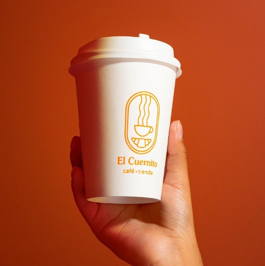 El Cuernito takeaway cup held against an orange wall
